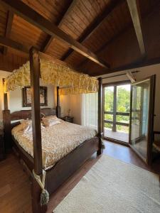a bedroom with a canopy bed and a large window at VILLA LAURA in Salceda