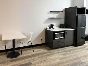 eine Küche mit einem schwarzen Kühlschrank sowie einem Tisch und Stühlen in der Unterkunft Studio 6 Elkhart IN in Elkhart