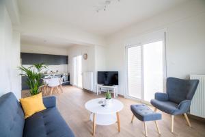 un soggiorno con divano, sedie e tavolo di Volos Horizon Oasis Apartment #1 a Volos