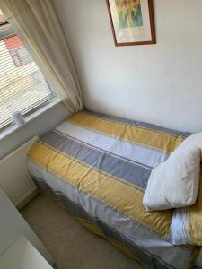 a small bed in a room with a window at Hadfield Avenue in Hoylake