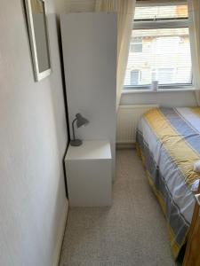 een slaapkamer met een bed en een lamp op een dressoir bij Hadfield Avenue in Hoylake