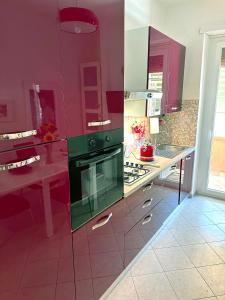 eine Küche mit rosa Wänden und einem grünen Backofen in der Unterkunft Royal Domus Of Rome in Rom