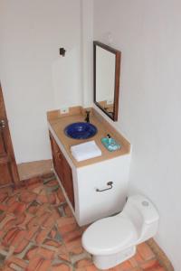 y baño con aseo y lavabo con espejo. en Color Marron casa de campo en Barichara