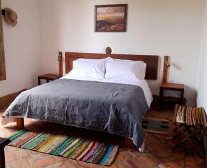1 dormitorio con 1 cama grande y cabecero de madera en Color Marron casa de campo en Barichara