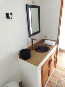une salle de bain avec un lavabo et un miroir dans l'établissement Color Marron casa de campo, à Barichara