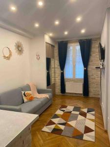 een woonkamer met een bank en een tapijt bij Charmant studio Côte d'Azur in Antibes