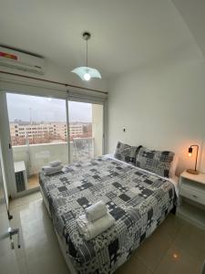 1 dormitorio con cama y ventana grande en Efimero San Juan, pleno centro en San Juan