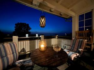 - une table en bois et 2 chaises sur une terrasse couverte la nuit dans l'établissement Villa Wiegand - a room with a view, à Holbæk