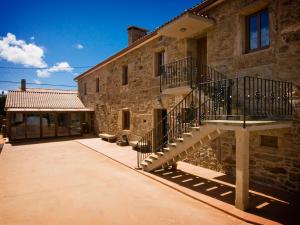 - un bâtiment en pierre avec des escaliers sur son côté dans l'établissement Casa Ceferinos, à Muxía