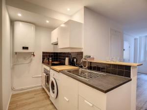 a white kitchen with a sink and a dishwasher at Eole appartement 2 pers 47m² in La Ciotat