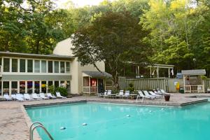 a swimming pool with chairs and a building at Eagles Nest Escape in Gatlinburg