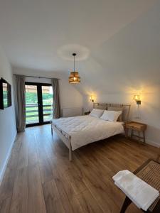 - une chambre avec un lit blanc et du parquet dans l'établissement Orastioara Retreat, 