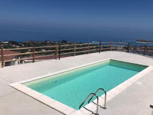 a swimming pool on a patio with the ocean in the background at Tropea Hills #5 in Santa Domenica