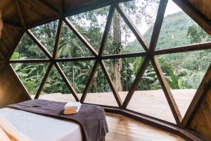 a room with a bed and a large window at Domo Deva Paraty in Paraty