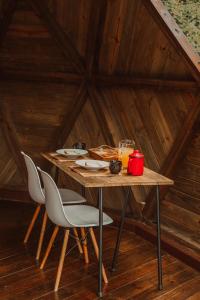 uma mesa de madeira com cadeiras num chalé de madeira em Domo Deva Paraty em Paraty