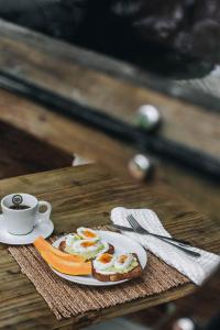 um prato de comida de pequeno-almoço e uma chávena de café numa mesa em Domo Deva Paraty em Paraty