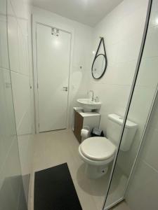 a white bathroom with a toilet and a sink at Apartamento confortável próximo ao Transamérica Expo in São Paulo