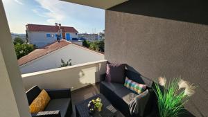 einen kleinen Balkon mit einem Sofa auf einem Gebäude in der Unterkunft Eximius Apartment in Pula