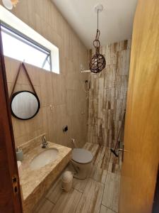 a bathroom with a sink and a toilet and a window at Condomínio Shalom Beach in Canoa Quebrada