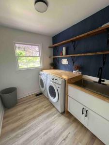 uma cozinha com uma máquina de lavar roupa e um lavatório em Newly renovated rancher with yard and garage! Furnished! em Williamsburg