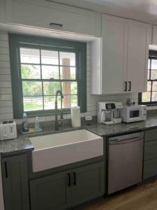 a kitchen with a large sink and a window at Newly renovated rancher with yard and garage! Furnished! in Williamsburg