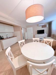un comedor blanco con una mesa y sillas blancas en Home Apartments en Seline