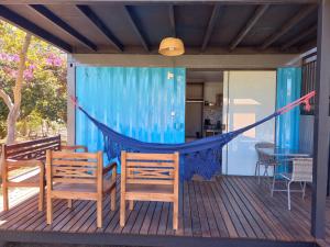 a hammock on the deck of a house at Villa de Assis Suítes in Alto Paraíso de Goiás