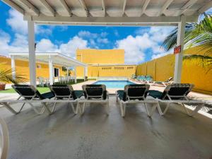 un patio con sillas y una piscina en The Gold Vacation Apartments en Santa Cruz