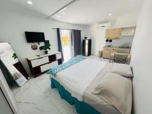 a bedroom with a large bed and a kitchen at The Gold Vacation Apartments in Santa Cruz