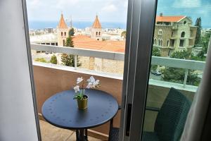a table on a balcony with a view of the city at Byblostar Hotel in Jbeil