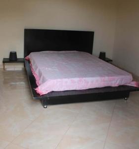 a large bed with a pink comforter in a room at Casa de Campo GONZÁLEZ in Pedra Badejo