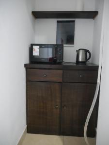a microwave sitting on top of a wooden cabinet at Habitación Privada en Edificio de Departamentos in Salta