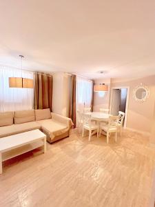 sala de estar con sofá y mesa en Home Apartments en Seline