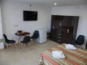 Schlafzimmer mit einem Bett, einem Tisch und einem TV in der Unterkunft Habitación Privada en Edificio de Departamentos in Salta