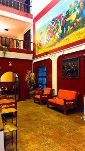 een kamer met banken en een schilderij aan de muur bij Hostel Sillustani Inn Puno in Puno