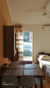 um quarto com uma mesa e cadeiras e uma janela em DLX Apartman Adriatics em Herceg Novi