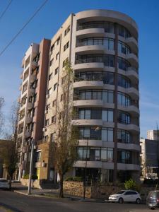 a tall building with cars parked in front of it at Habitación Privada en Edificio de Departamentos in Salta