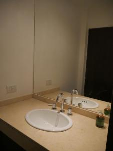 eine Badezimmertheke mit einem Waschbecken und einem Spiegel in der Unterkunft Habitación Privada en Edificio de Departamentos in Salta