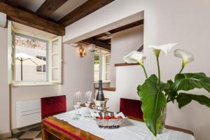 Holiday Home City Walls في هفار: غرفة طعام مع طاولة و مزهرية مع الزهور البيضاء