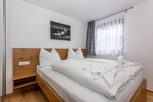 1 cama blanca grande en una habitación con ventana en Villa Oberbichl, en Piesendorf