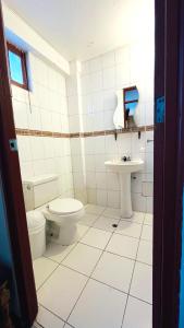 y baño con aseo y lavamanos. en Hostel Sillustani Inn Puno, en Puno