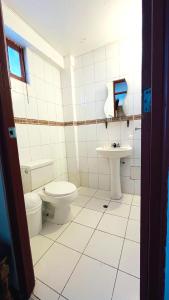 a bathroom with a toilet and a sink at Hostel Sillustani Inn Puno in Puno