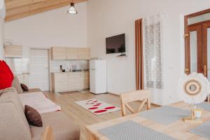 a living room with a couch and a kitchen at Pensiunea Suzanne Băile Figa in Beclean