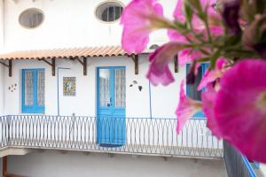 un edificio con puertas azules y flores rosas en Centrale, en Trapani