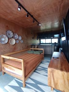 a bedroom with a bed and a wooden table at Nomada Republic Hotel El valle in Antón