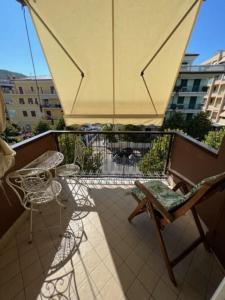 balcone con ombrellone, tavolo e sedie di A cà di nonni ad Albenga