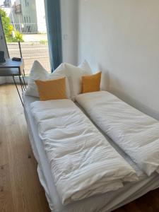 ein großes weißes Bett mit zwei Kissen darauf in der Unterkunft UNiQE I 90qm I Terrasse in Rosenheim