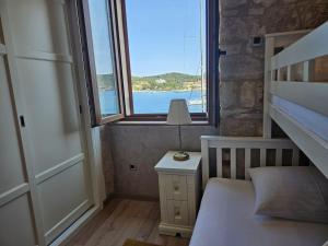 a bedroom with a bed and a window with a view of the ocean at Luxury Seafront Suite Fabri in Vis
