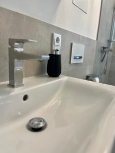 a bathroom sink with a soap dispenser on it at UNiQE I 90qm I Terrasse in Rosenheim
