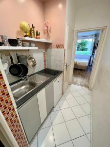 a small kitchen with a sink and a window at Studio situé à 5 min du château de Versailles et stationnement gratuit in Versailles